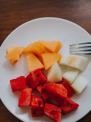 sliced watermelon and mango on plate with fork