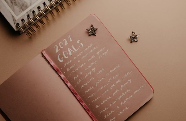 Top view of a 2021 goals notebook with handwritten list and star decorations, ideal for planning inspiration.